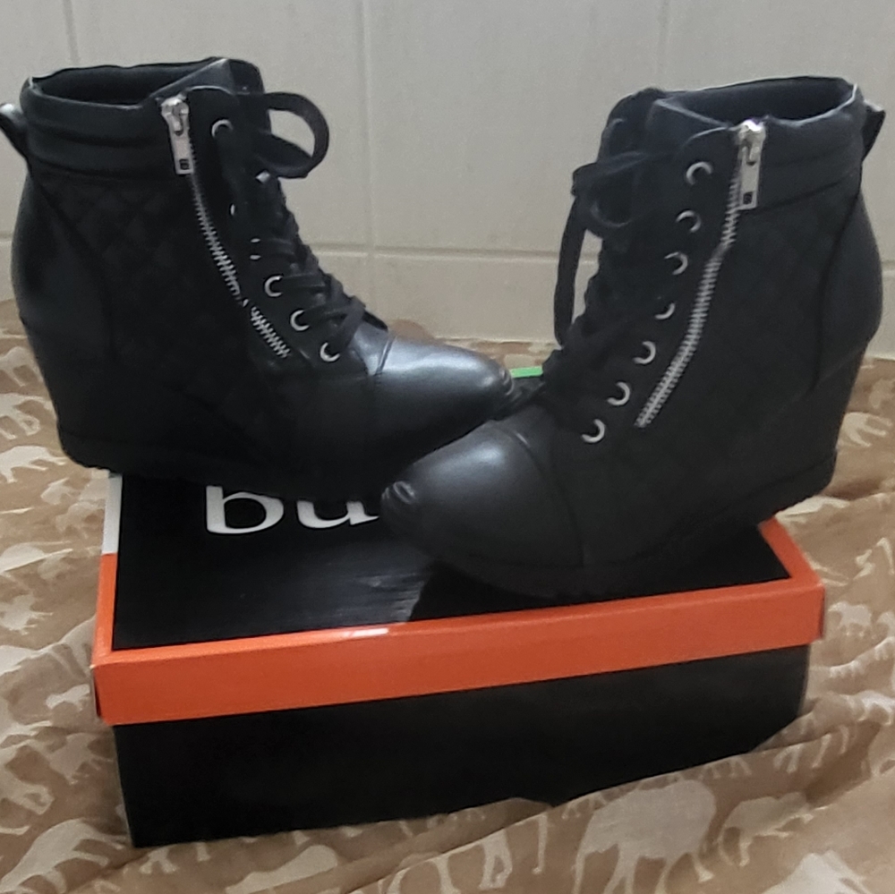 Black boots with wedged heel.that measures 3 inches from highest point.